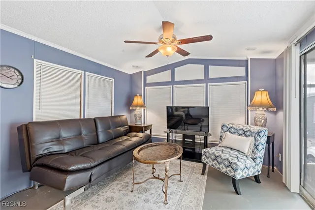 a living room with furniture a flat screen tv and a window