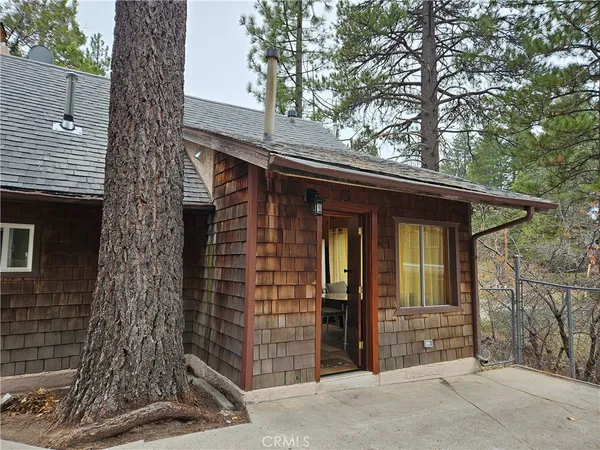 a front view of a house with a tree