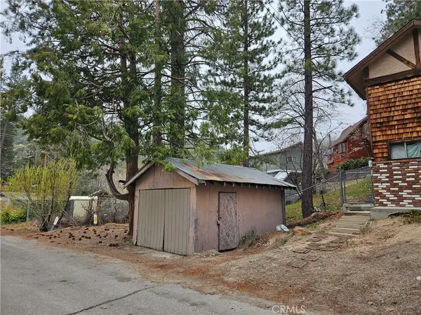 a wooden house with a tree in front of it
