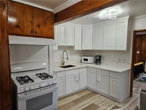 a kitchen with stainless steel appliances a stove a sink and cabinets