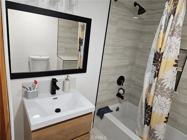 a bathroom with a tub sink and mirror