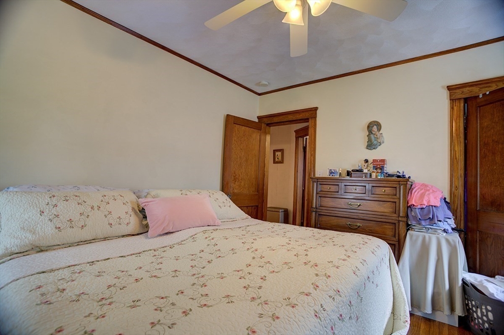 44 Cottage Park Road Winthrop, MA 02152 - Photo 33 of 39 a bedroom with a bed and a dresser with a chandelier