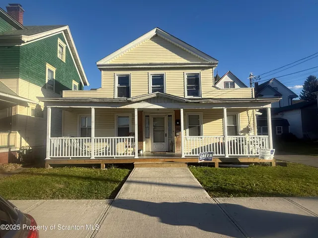 a front view of a house with a garden and porch