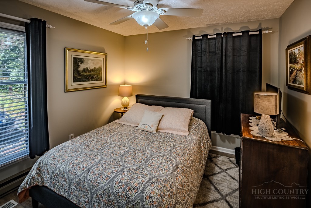 38 Rocky Meadows Road Newland, NC 28657 - Photo 24 of 50 a bedroom with a bed and a chandelier