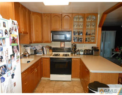 12 Rosewood Road Edison, NJ 08817 - Photo 3 of 14 a kitchen with stainless steel appliances a stove a sink and a refrigerator