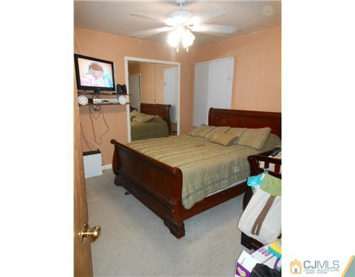 12 Rosewood Road Edison, NJ 08817 - Photo 8 of 14 a bedroom with a bed and a chandelier