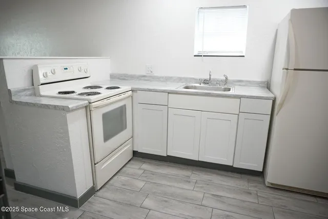 a view wooden cabinets and a refrigerator