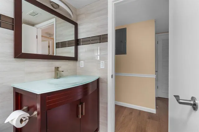 a bathroom with a granite countertop sink and a mirror