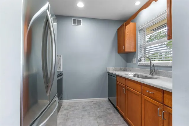 a kitchen with stainless steel appliances granite countertop a refrigerator and a sink