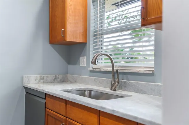 a kitchen with a sink a window and cabinets
