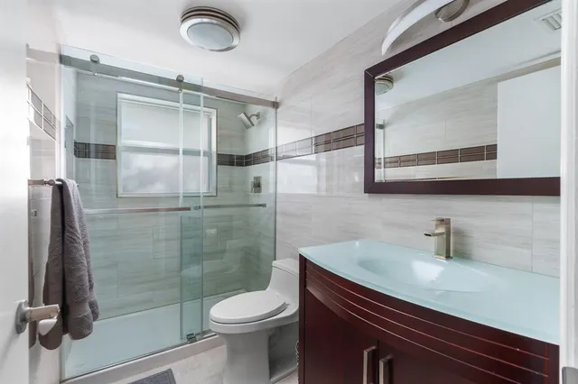 a bathroom with a sink a toilet and shower