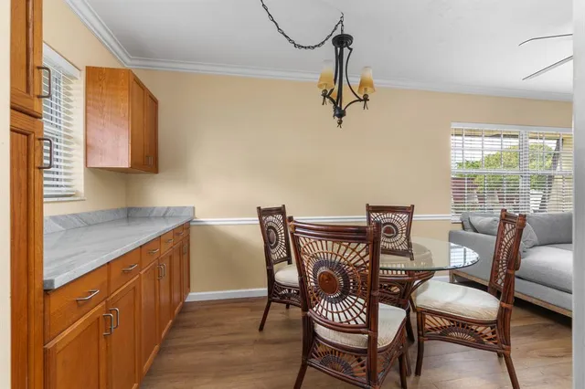 a dining room with furniture a chandelier and wooden floor