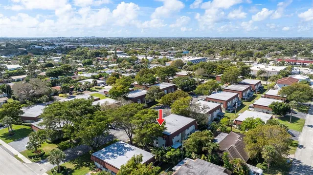 an aerial view of residential houses with outdoor space and trees