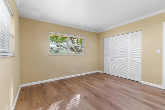 a view of a hallway with wooden floor and closet