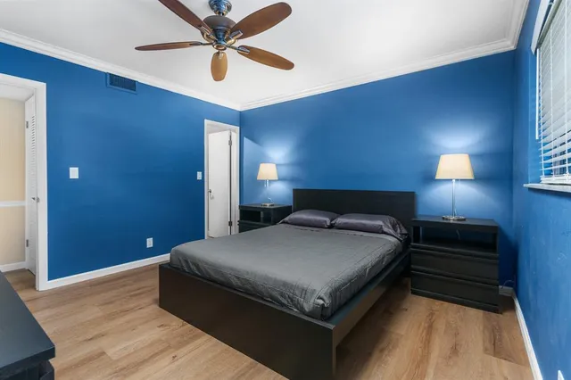 a spacious bedroom with a bed and a chandelier