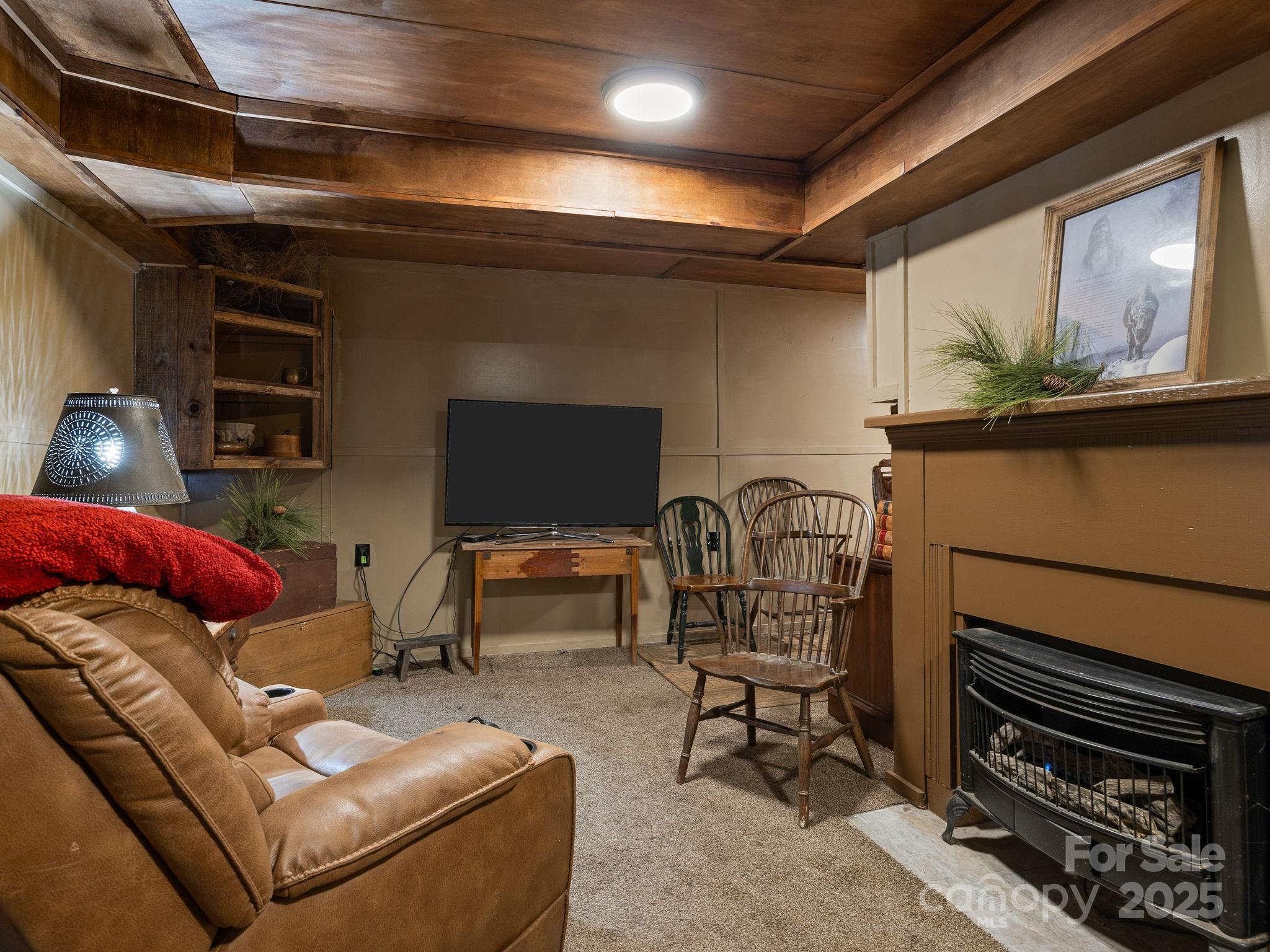 1933 John Shehan Road Mill Spring, NC 28756 - Photo 19 of 25 a living room with furniture a flat screen tv and a fireplace
