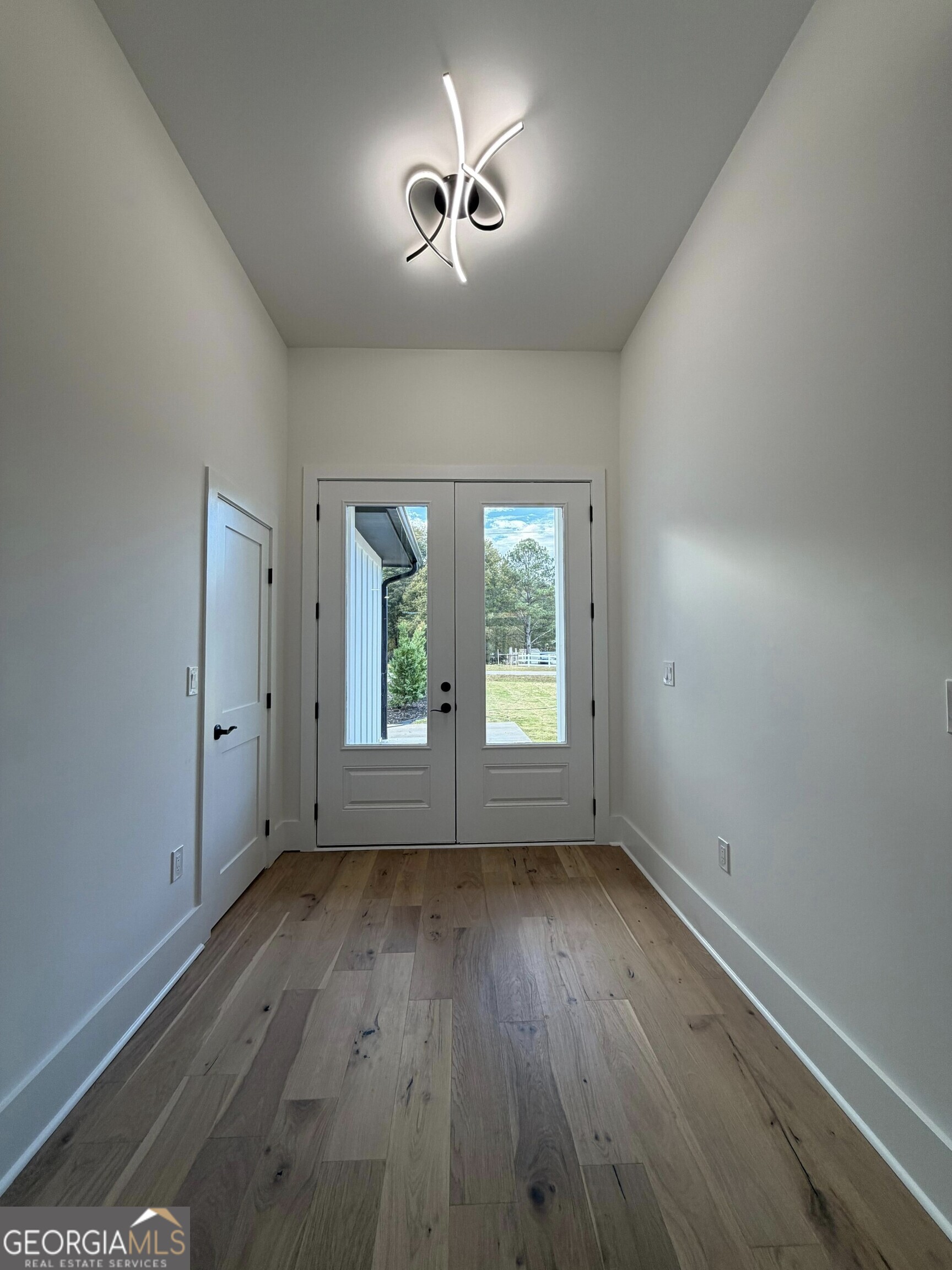 2590 Walton Downs Road, Unit 3 Monroe, GA 30655 - Photo 11 of 37 an empty room with a window and wooden floor