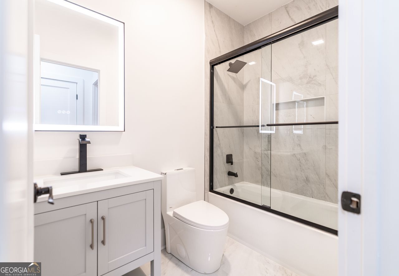 2590 Walton Downs Road, Unit 3 Monroe, GA 30655 - Photo 17 of 37 a bathroom with a granite countertop sink mirror vanity and toilet