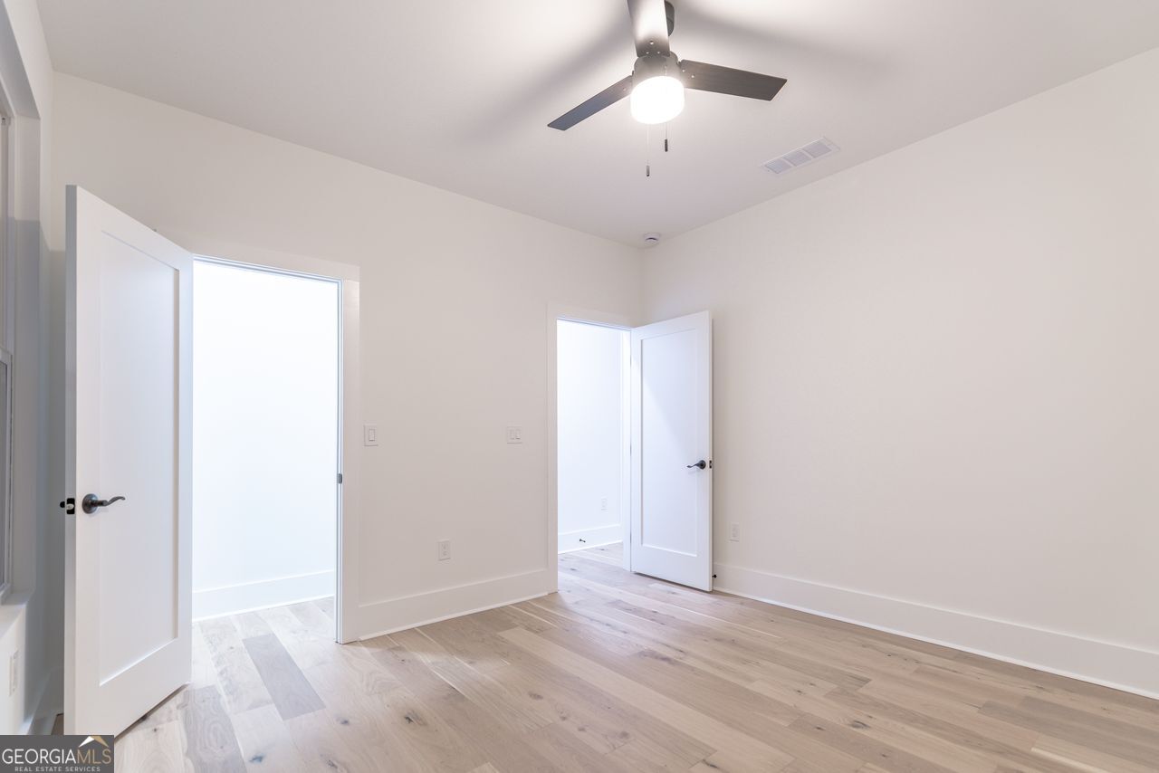 2590 Walton Downs Road, Unit 3 Monroe, GA 30655 - Photo 18 of 37 an empty room with wooden floor and ceiling fan