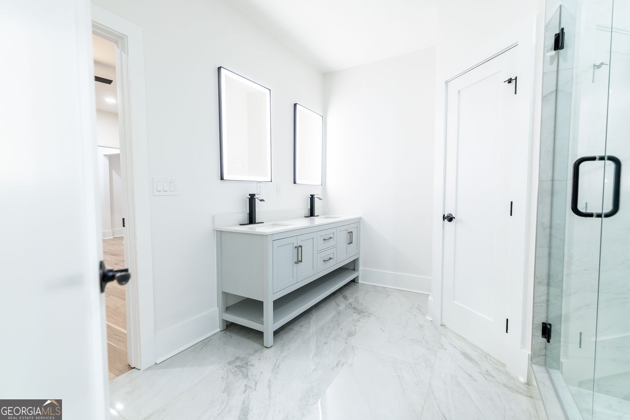 2590 Walton Downs Road, Unit 3 Monroe, GA 30655 - Photo 22 of 37 a bathroom with a double vanity sink a mirror and a shower
