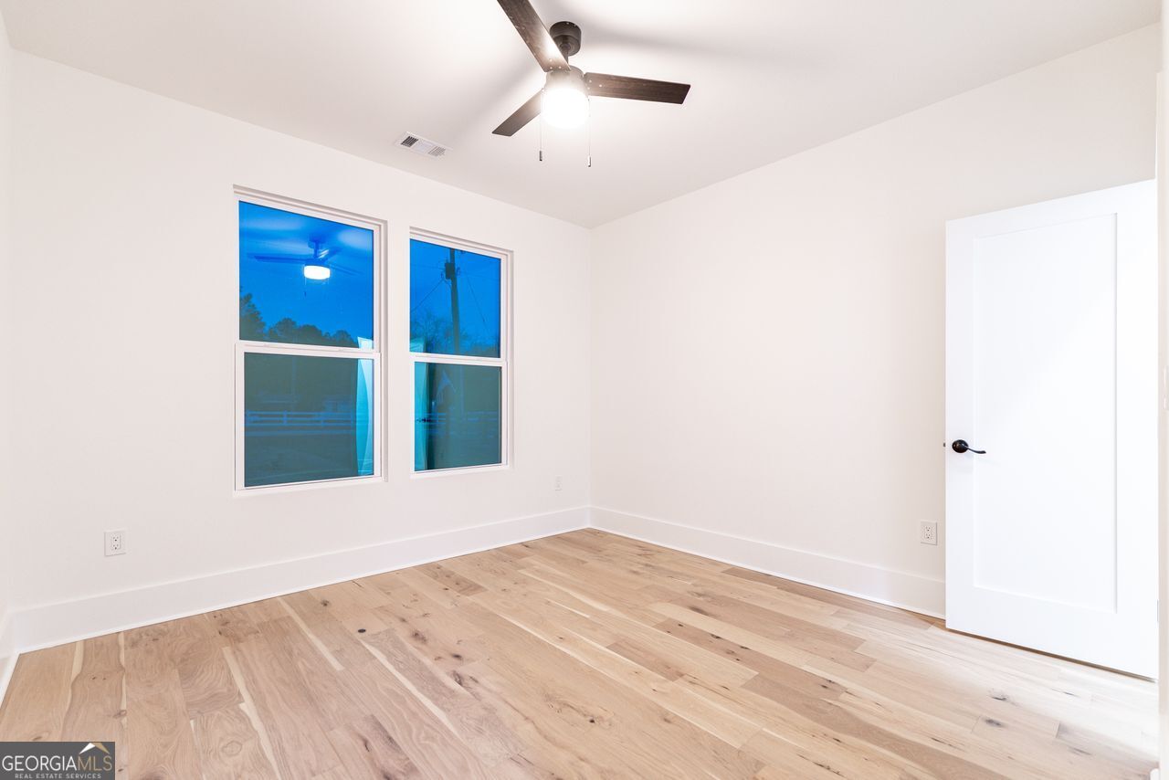 2590 Walton Downs Road, Unit 3 Monroe, GA 30655 - Photo 26 of 37 an empty room with wooden floor and windows