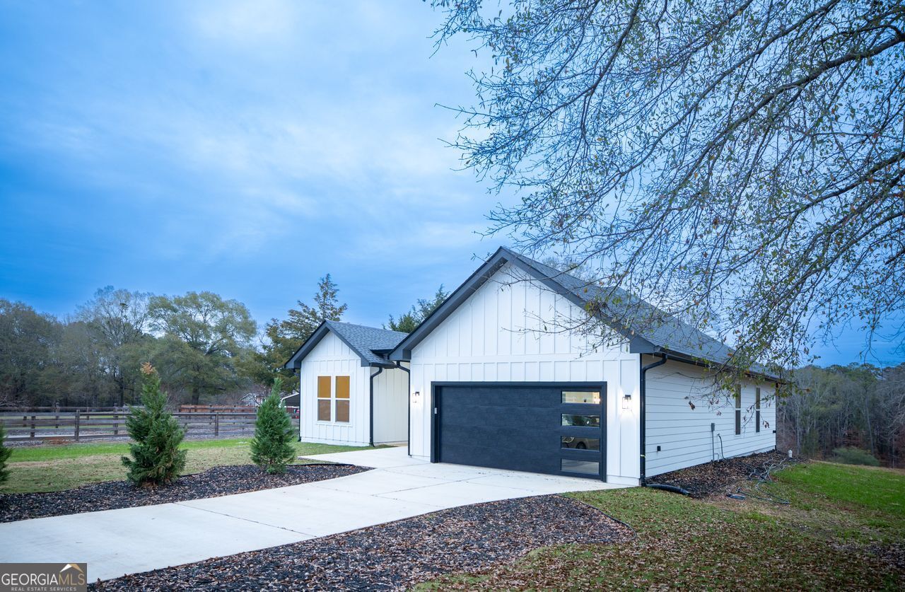 2590 Walton Downs Road, Unit 3 Monroe, GA 30655 - Photo 3 of 37 a front view of a house with a yard and garage