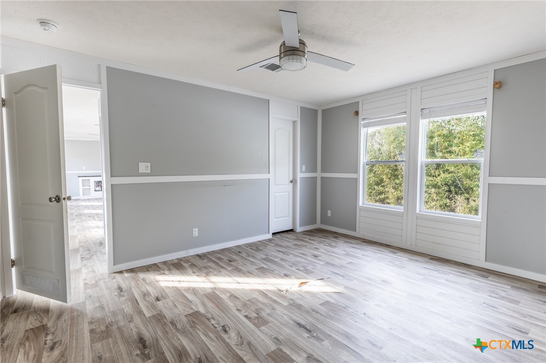 117 Royal Street Taylor, TX 76574 - Photo 12 of 16 a view of empty room with wooden floor and fan