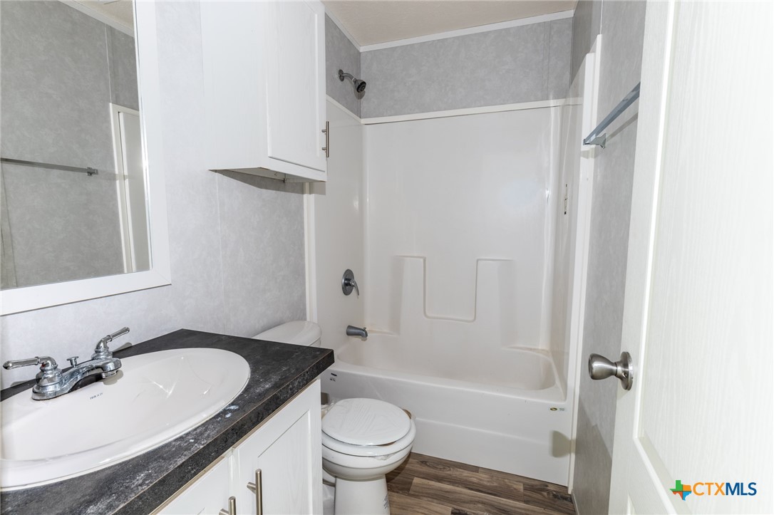 117 Royal Street Taylor, TX 76574 - Photo 15 of 16 a bathroom with a granite countertop sink toilet and shower