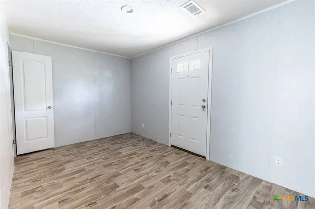 an empty room with wooden floor and closet