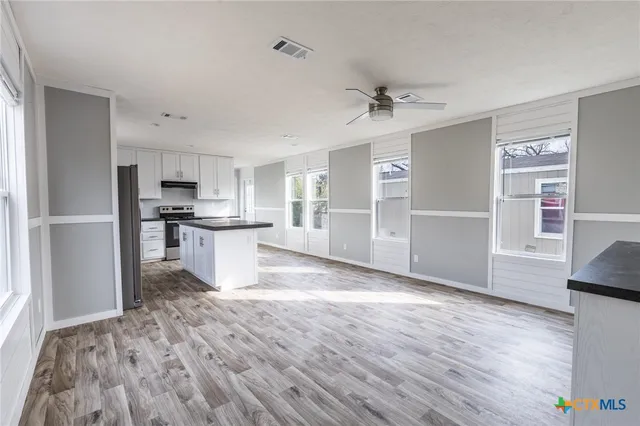 a view of kitchen with wooden floor electronic appliances and window
