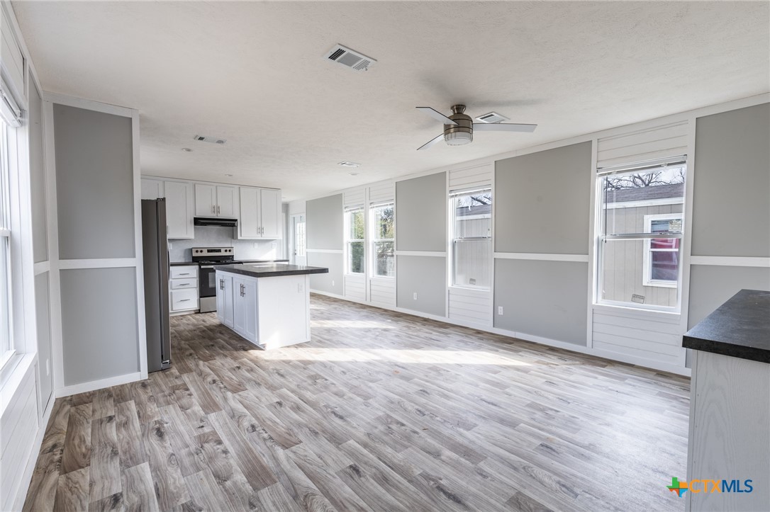117 Royal Street Taylor, TX 76574 - Photo 6 of 16 a view of kitchen with wooden floor electronic appliances and window