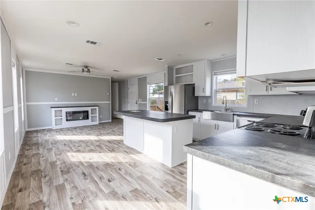 a large kitchen with kitchen island a stove a sink and a counter space