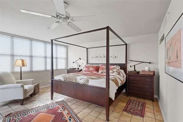 a bedroom with a bed a couch and a window
