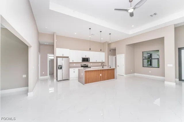 a large white kitchen with a refrigerator a stove top oven a sink and a refrigerator