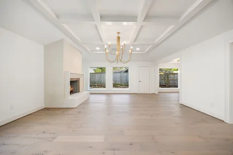 a large white kitchen with a stove top oven a sink dishwasher and a refrigerator with wooden floor