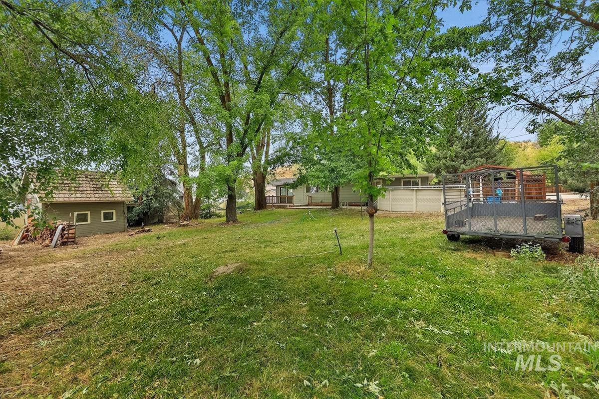 7141 West Hill Road Boise, ID 83714 - Photo 27 of 28 Expansive exterior space featuring mature trees and a substantial outbuilding with wood paneling