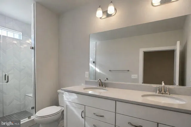 a spacious bathroom with a double vanity sink and mirror