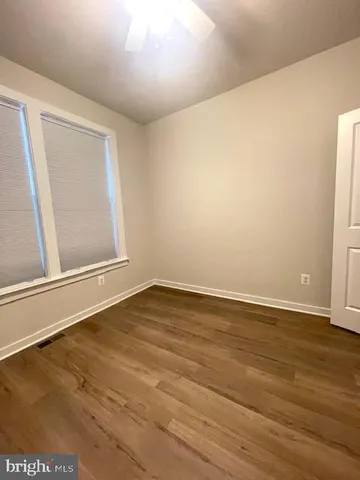 an empty room with wooden floor and white walls