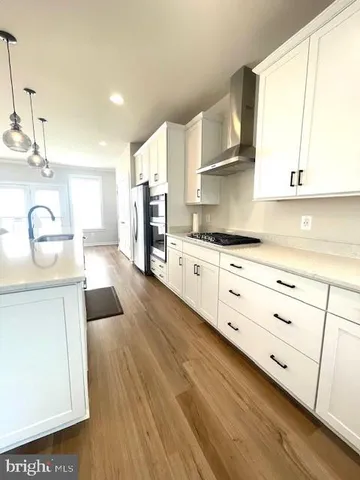 a kitchen with granite countertop a sink cabinets stainless steel appliances and a window