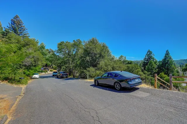 an aerial view of residential houses with outdoor space and trees