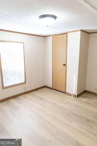 an empty room with windows and closet