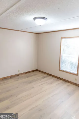 an empty room with a window and a projector screen