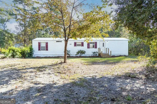 a view of a house with backyard and tree