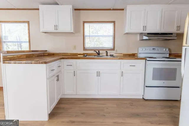 a kitchen with granite countertop white cabinets and white appliances