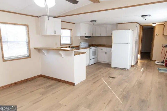 a kitchen with a refrigerator a stove top oven a counter space and a window