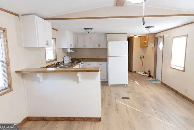 a kitchen with kitchen island a counter top space a sink stainless steel appliances and cabinets