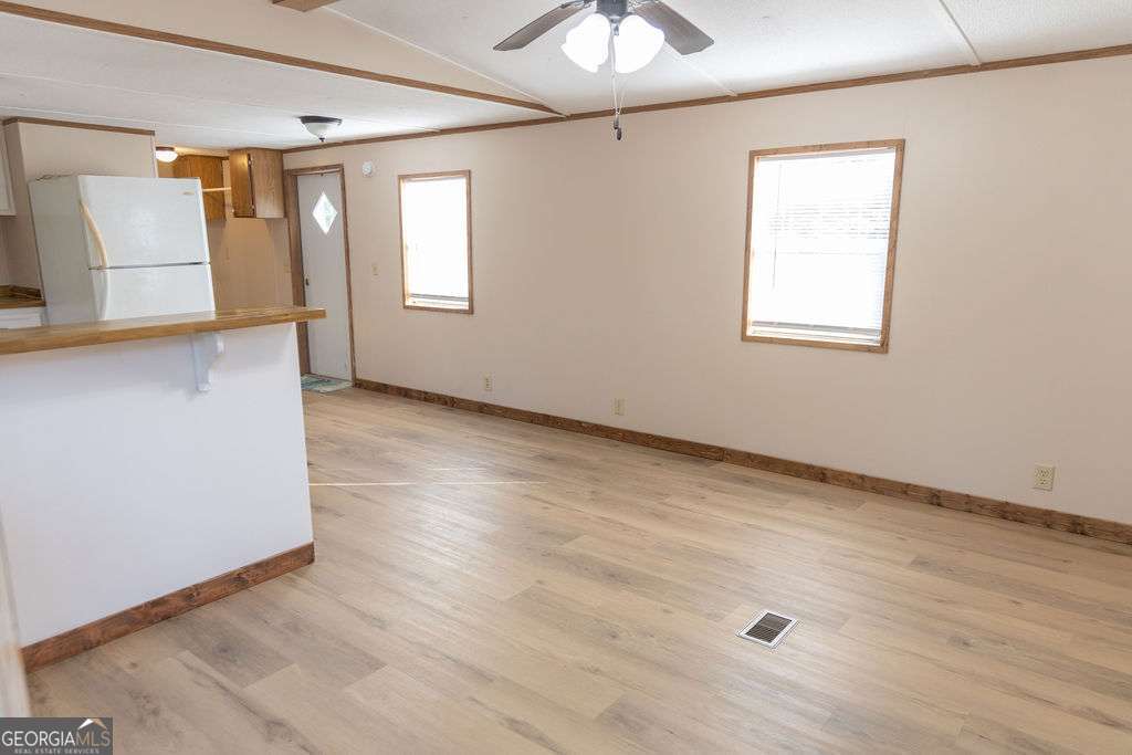 629 Sierra Road Jesup, GA 31545 - Photo 9 of 23 an empty room with wooden floor and windows