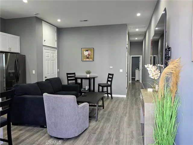 a kitchen with a refrigerator a stove a sink a dining table and chairs