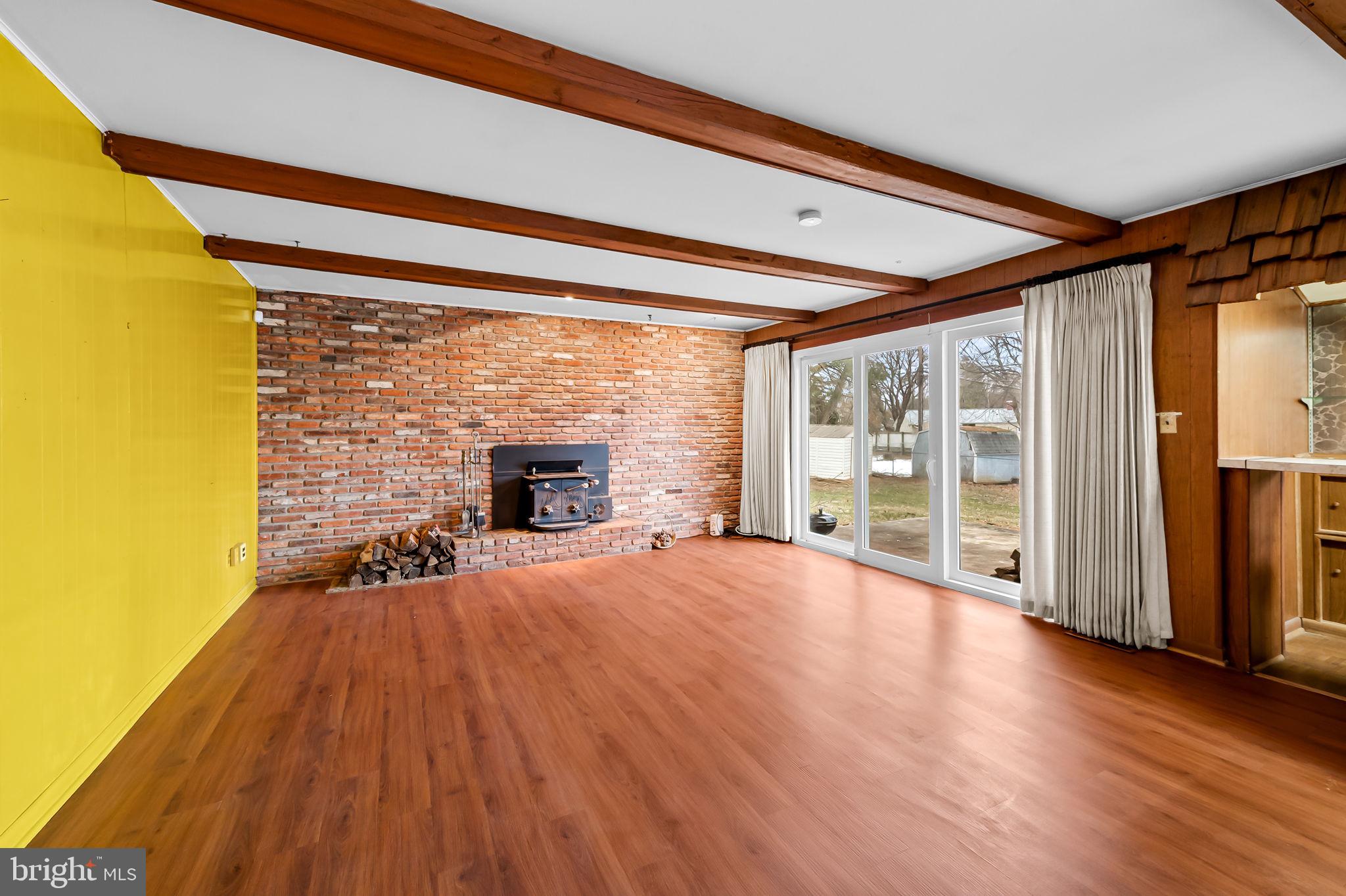 10 Geier Court Randallstown, MD 21133 - Photo 14 of 35 a empty room with a fireplace and wooden floor