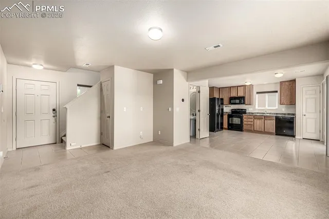 a view of a kitchen with refrigerator and a sink